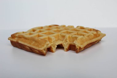 Bir ısırılmış waffle keki, beyaz arka planda izole edilmiş.