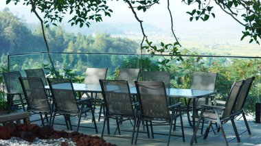 Etrafı dağlarla ve ağaçlarla çevrili güzel otel bahçesi manzarası.