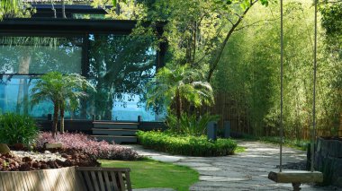 Etrafı dağlarla ve ağaçlarla çevrili güzel otel bahçesi manzarası.