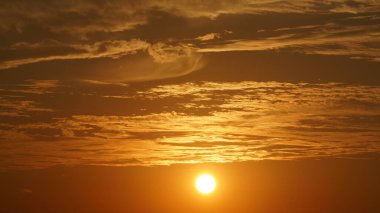 Güzel gün batımı manzarası, renkli bulutlar ve gökyüzünde sıcak ışıklar.
