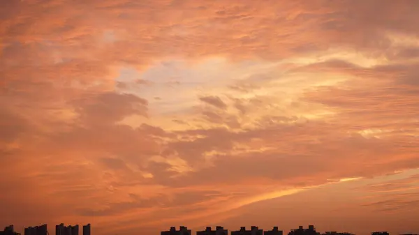 美丽的夕阳西下的天空映衬着五彩斑斓的云彩和温暖的灯光 — 图库照片