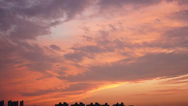美丽的夕阳西下的天空映衬着五彩斑斓的云彩和温暖的灯光 — 图库照片