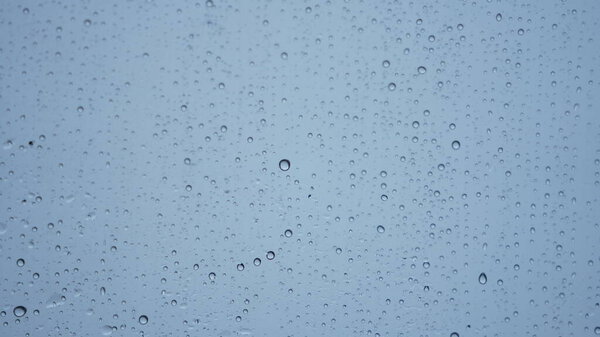 The rain droplets on the transparent glass window in the rainy day