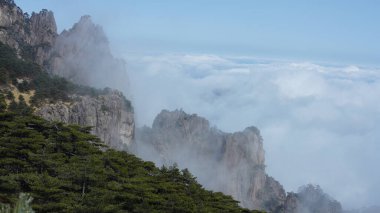 Yeşil ormanlı güzel dağlar ve püsküren kaya uçurumları Çin 'in kırsal kesimlerinde arka plan olarak kullanılıyor.