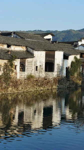 中国南部の田園地帯にある古いアーチ型の石造りの橋と古い木造建築物のある古い中国の伝統的な村の景色 — ストック写真