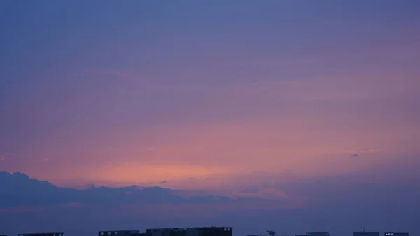 街の背景として建物のシルエットとオレンジの空と美しい夕日の景色 — ストック写真