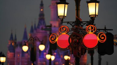 Renkli binaları ve ışıkları açık olan Disney Kalesi manzarası.