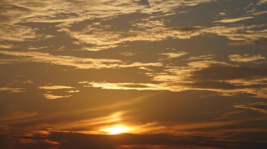 Şehrin arka planında binaların silueti ve turuncu renkli gökyüzü olan güzel günbatımı manzarası