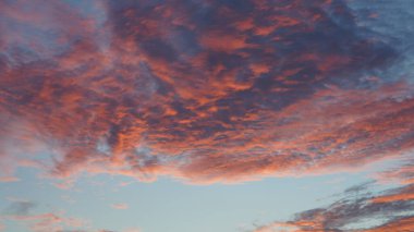 Şehrin arka planında binaların silueti ve turuncu renkli gökyüzü olan güzel günbatımı manzarası