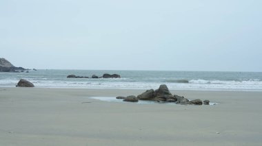 Okyanus sahili manzarası, kaya kıyısı ve gelgit dalgaları.