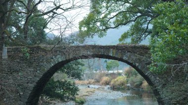 Çin 'in güneyinde eski taş kemerli köprüsü ve deresi olan güzel kırsal alan.