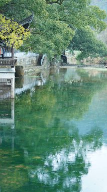 Güzel Çin köyü manzarası Yağmurlu bir günde sudaki yansımasıyla
