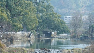Eski köy binalarının Çin 'in güneyindeki suda yansıdığı güzel kırsal manzara.