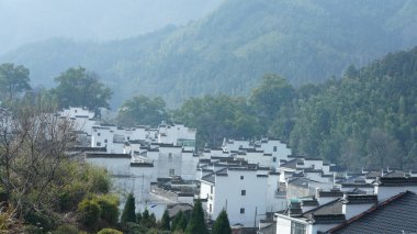 Çin 'in güneyinde eski köy ve dağlarla güzel bir kır manzarası.