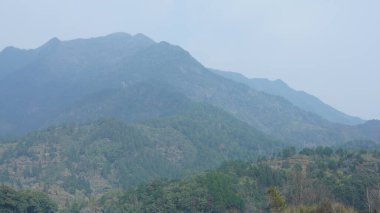 Çin 'in güneyinde eski köy ve dağlarla güzel bir kır manzarası.