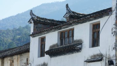 Çin 'in güneyindeki eski köyde beyaz duvarı ve siyah saçakları olan eski ahşap ev.