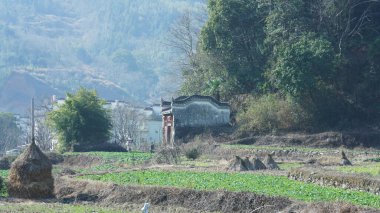 Çin 'in güneyinde eski köy ve dağlarla güzel bir kır manzarası.