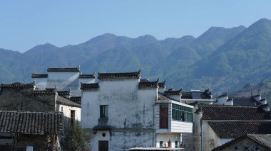 Çin 'in güneyinde eski köy ve dağlarla güzel bir kır manzarası.
