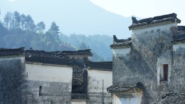 Çin 'in güneyinde eski köy ve dağlarla güzel bir kır manzarası.
