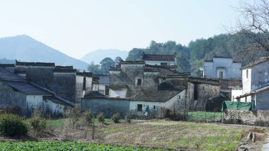Çin 'in güneyinde eski köy ve dağlarla güzel bir kır manzarası.