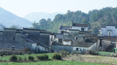 Çin 'in güneyinde eski köy ve dağlarla güzel bir kır manzarası.