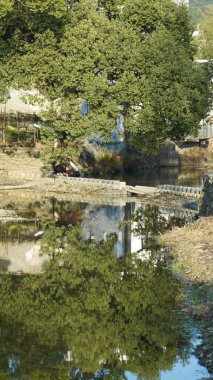 Eski köy binalarının Çin 'in güneyindeki suda yansıdığı güzel kırsal manzara.