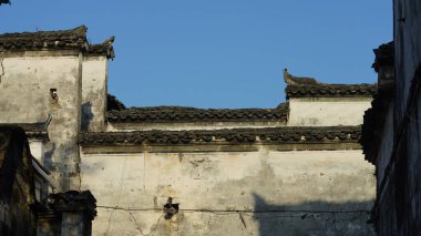 Çin 'in güneyindeki eski köyde beyaz duvarı ve siyah saçakları olan eski ahşap ev.