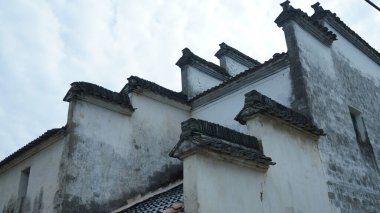 Çin 'in güneyindeki eski köyde beyaz duvarı ve siyah saçakları olan eski ahşap ev.