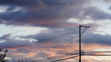 Renkli bulutlar ve sıcak güneş ışığıyla güzel gün batımı manzarası.