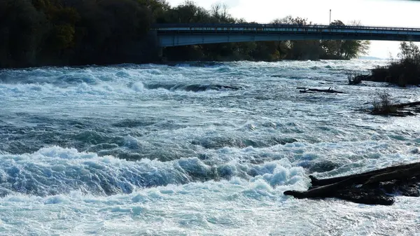 Sonbaharda akan sular ve renkli ormanlarla dolu güzel nehir manzarası.