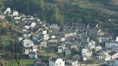 Yeşil ormanı olan güzel dağlar ve Çin kırsalının arka planında küçük bir köy.