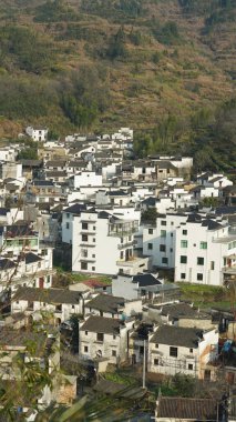 Yeşil ormanı olan güzel dağlar ve Çin kırsalının arka planında küçük bir köy.