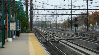 Tren istasyonu manzaralı, platformun yanında demir raylar var.
