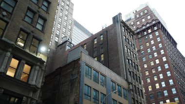 Arka planda gökdelenler ve eski binalar olan New York şehri manzarası.
