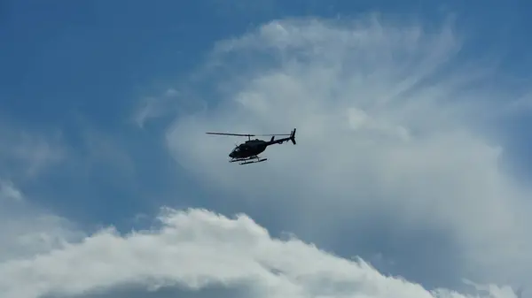 stock image One helicopter flying over in the blue sky in autumn