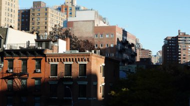 Arka planda gökdelenler ve eski binalar olan New York şehri manzarası.
