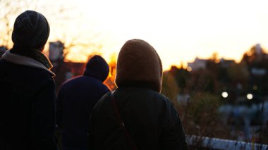 Gün batımı manzarası, şehirde siluet ve sarı gökyüzü.