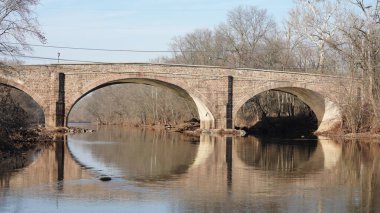 Amerika 'nın kırsal kesiminde nehrin üzerinden geçen eski bir kemerli köprü.