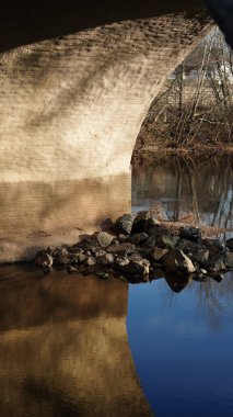 Amerika 'nın kırsal kesiminde nehrin üzerinden geçen eski bir kemerli köprü.