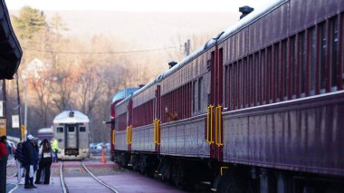 The railway station view with the wagons stopping on the iron tracks clipart