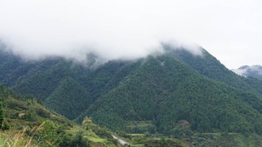 Yeşil ormanlı güzel dağlar ve yağmurlu günlerde arka planda kalan küçük köyler.