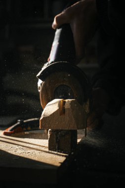 Ahşap işçiliğine yakın plan, tahtadan süzülen talaşları yakalamak. Dramatik ışıklandırma, işçiliğin gerektirdiği ayrıntıları ve beceriyi vurguluyor..