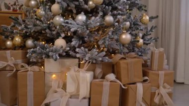 Noel ağacının altında süslerle süslenmiş ve parlayan ışıklarla süslenmiş güzel paketlenmiş hediyelerin yakın plan fotoğrafları. Festival ve tatil teması için mükemmel..