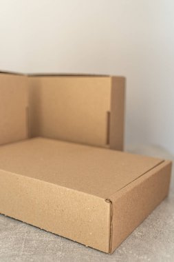 Tarafsız bir arkaplanda gösterilen çevre dostu Kraft karton kutularının yakın görüntüsü. Sürdürülebilir ambalaj, hediye paketleme, depolama ve nakliye ihtiyaçları için mükemmel.. 