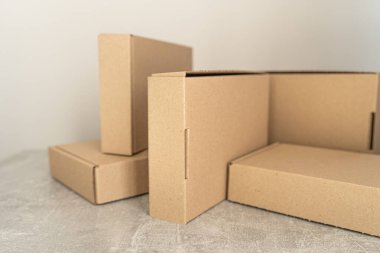 Tarafsız bir arkaplanda gösterilen çevre dostu Kraft karton kutularının yakın görüntüsü. Sürdürülebilir ambalaj, hediye paketleme, depolama ve nakliye ihtiyaçları için mükemmel.. 