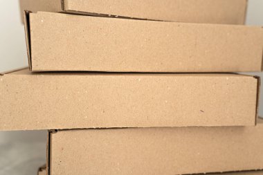 Tarafsız bir arkaplana karşı dizilmiş kraft karton kutuların detaylı yakın çekimi. Çevre dostu ambalaj, hediye paketleme, nakliye ve depolama çözümleri için ideal. 
