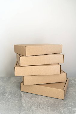 Kendi kendine monte edilen kraft karton kutular desenli bir yüzeye yerleştirilmiş. Paketleme, hediye paketleme ve nakliye için ideal. İşletmeler ve tatil hazırlıkları için sürdürülebilir bir seçim.