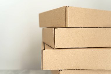 Kendi kendine monte edilen kraft karton kutular desenli bir yüzeye yerleştirilmiş. Paketleme, hediye paketleme ve nakliye için ideal. İşletmeler ve tatil hazırlıkları için sürdürülebilir bir seçim.