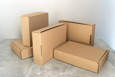 Bir desenli yüzey üzerinde kendi kendine monte edilen kraft karton kutular. Paketleme, nakliye ve hediye paketleme için mükemmel. Çeşitli kullanımlar için sürdürülebilir ve çevre dostu. 