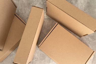 Kraft karton kutularının dokulu bir yüzeye yerleştirilmiş havadan perspektifi. Sürdürülebilir ambalaj, hediye, nakliye ve çevresel bilinçli depolama çözümleri için ideal. 